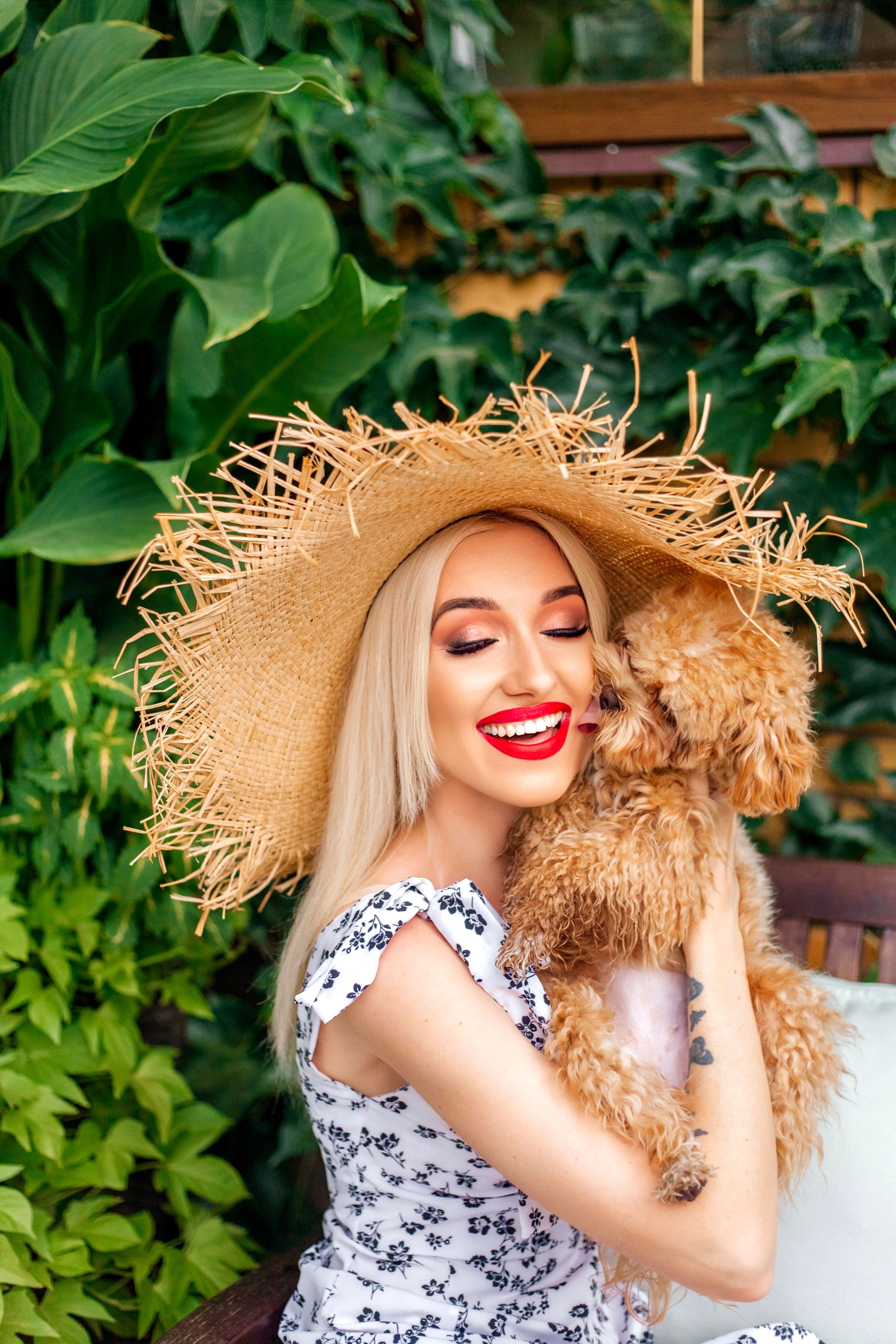 Tutora sorrindo com os olhos fechados enquanto abraça uma poodle caramelo
